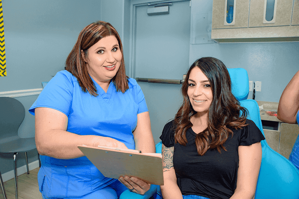 dentist in Waco, TX, talking to a female patient about braces